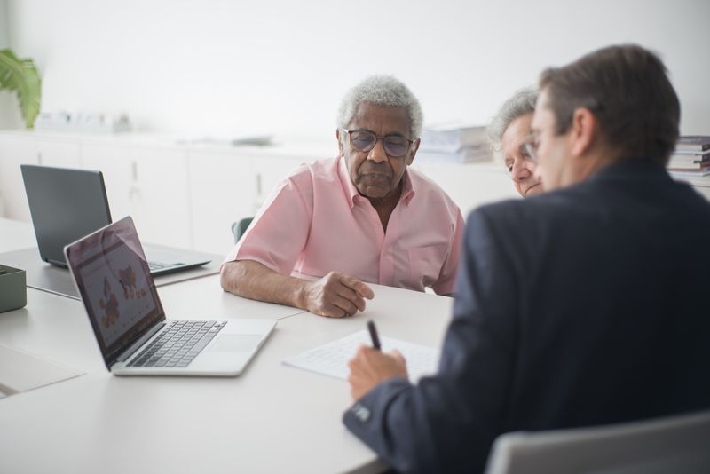 Elderly couple discussing contract with consultant - Medicare Advantage